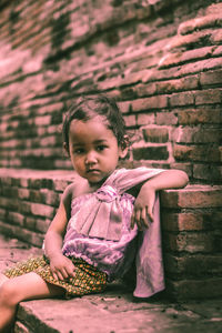 Portrait of cute girl sitting outdoors