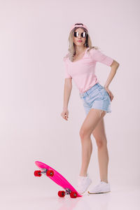 Portrait of young woman standing against white background