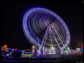 Low angle view of illuminated ferris wheel at night