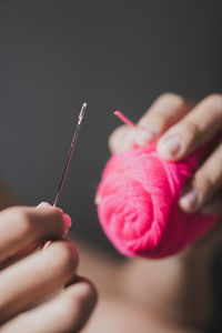 Midsection of woman holding syringe against black background