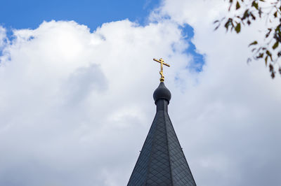 Orthodox cross on domes againts blue sky with clouds