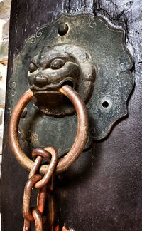Close-up of rusty chain on metal gate