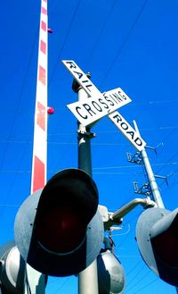 Low angle view of road sign against blue sky