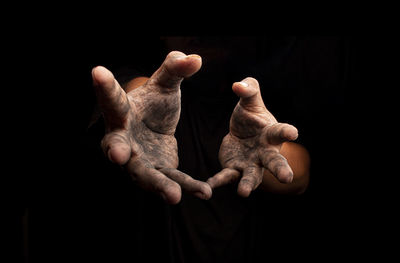 Close-up of human hand against black background