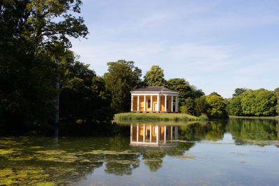 Built structure by lake against sky