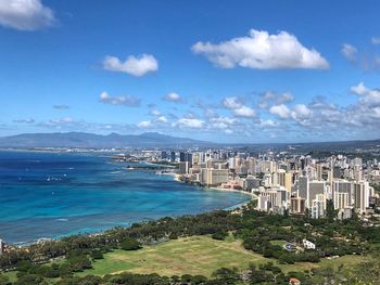 High angle view of city by sea against sky