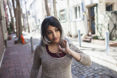 Portrait of beautiful woman standing on street in city