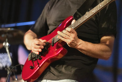 Midsection of man playing guitar