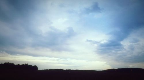 Low angle view of silhouette trees against sky