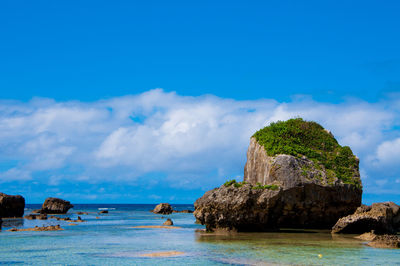 Rocks on sea shore against sky