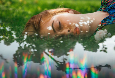 Digital composite image of woman sleeping at lakeshore