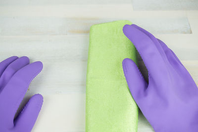 Close-up of person wearing gloves while cleaning floor