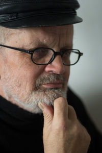 Close-up of thoughtful senior man wearing eyeglasses looking away at home