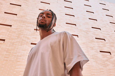 Low angle view of man looking away against building