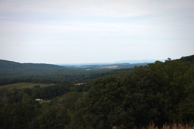 Scenic view of green landscape and mountains against sky