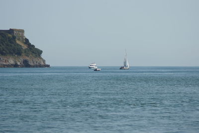 Sailboat sailing on sea against clear sky