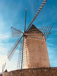 Low angle view of traditional windmill against sky