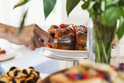 Cropped image of hand arranging desert on cakestand at cafe