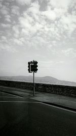 Road signal on street against sky