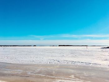 Scenic view of beach against blue sky
