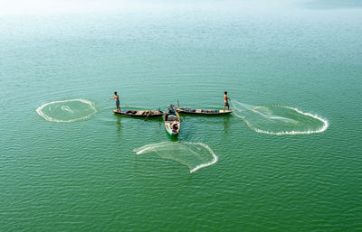 High angle view of people fishing on boat in sea