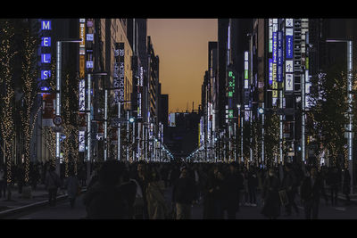 Crowd in city against sky at night