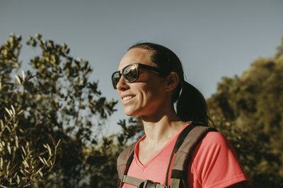 Portrait of smiling man standing by plants against sky