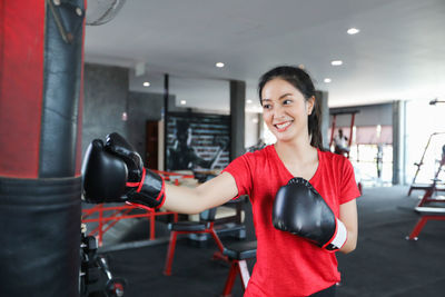 Young woman punching bag at gym