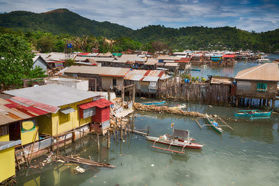 High angle view of buildings by river against sky