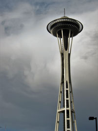 Low angle view of ferris wheel against cloudy sky