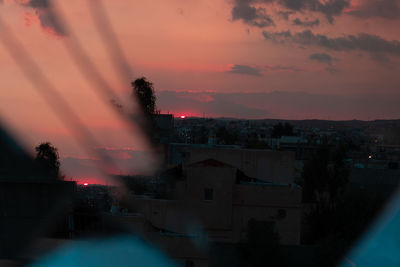 Illuminated buildings against sky during sunset