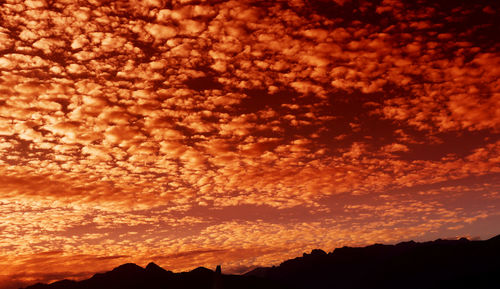 Low angle view of silhouette mountain against romantic sky