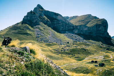 Massive rock formation in durmitor national park with motorcycle in the distance