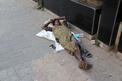 High angle view of man sleeping on footpath