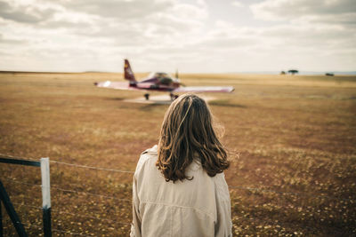 Woman looking at propeller airplane during weekend