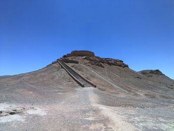 Low angle view of castle on mountain against blue sky