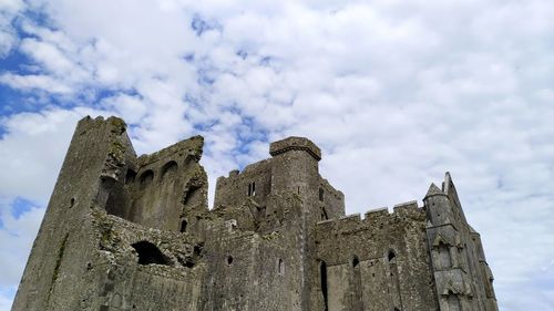 Low angle view of old building against cloudy sky