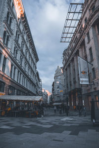 City street by buildings against sky