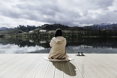 Rear view of woman on jetty against sky