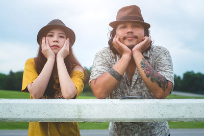 Portrait of smiling young woman looking away against sky