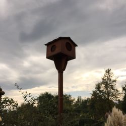 Low angle view of birdhouse on field against sky