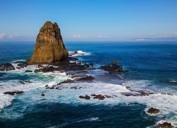 Rock formation in sea against sky