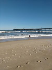 Scenic view of beach against clear blue sky