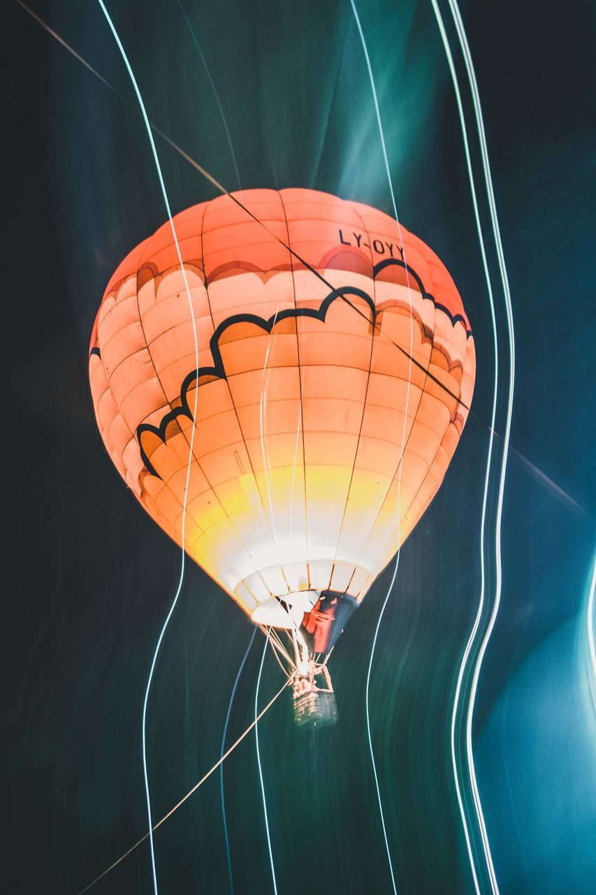 balloon, hot air balloon, flying, nature, mid-air, air vehicle, parachute, orange color, outdoors, illuminated, transportation, no people, day, extreme sports, text, low angle view, water, adventure