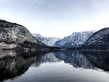 Scenic view of lake by snowcapped mountains against sky