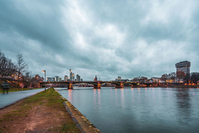 Bridge over river against buildings in city