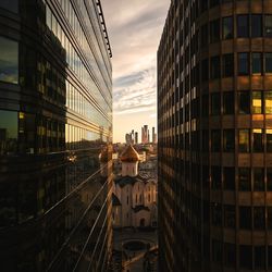 Buildings in city against sky at sunset