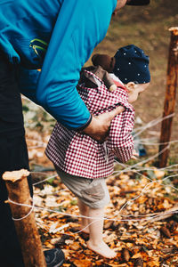 Rear view of mother and daughter on autumn leaves