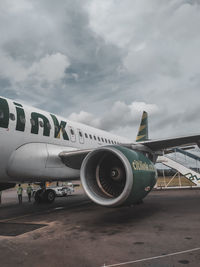 Airplane on airport runway against sky