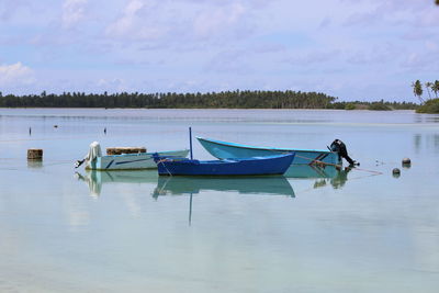 Boats moored in lake against sky